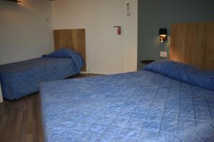 布尔德佩阿日卡特酒店的一间卧室配有蓝色的床和蓝色的被子