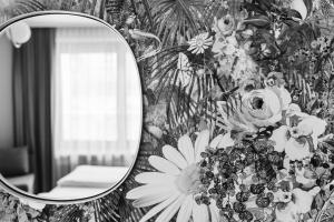 萨尔茨堡威瑟陶贝老城区酒店的墙上的镜子,带花卉壁纸