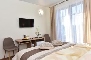 特拉凯全景酒店的一间卧室配有一张床、一张书桌和一台电视