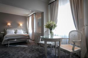 科尔马Grand Hôtel Bristol的一间卧室配有一张床和一张花瓶桌子