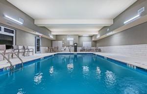 CoffeyvilleHoliday Inn Express & Suites - Coffeyville, an IHG Hotel的游泳池,酒店客房带椅子