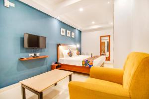 耶拉汉卡FabHotel The Sun Suites Vinayaka Nagar的一间卧室配有一张床、一张沙发和一台电视。