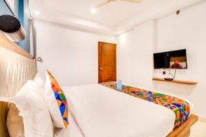 耶拉汉卡FabHotel The Sun Suites Vinayaka Nagar的一间白色卧室,配有床和电视
