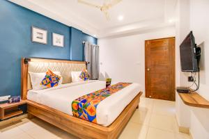 耶拉汉卡FabHotel The Sun Suites Vinayaka Nagar的一间卧室配有一张蓝色墙壁的床