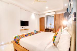 耶拉汉卡FabHotel The Sun Suites Vinayaka Nagar的一间带大床和电视的卧室