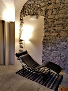 坎佩尔托尼奥Villa Ottocento的石墙房间内的一张黑椅子