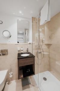 楚格络温西酒店的一间带水槽、淋浴和卫生间的浴室