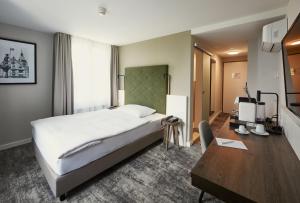 楚格络温西酒店的配有一张床和一张书桌的酒店客房