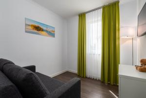 伯尔格伦德-雷特维施Ferienwohnungen Rosengarten的客厅配有绿色窗帘和沙发