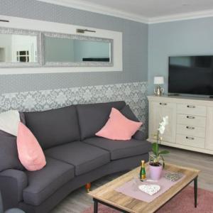 奥斯赛拜-屈隆斯博恩Ferienhaus Godewind的客厅配有黑色沙发和粉红色枕头。