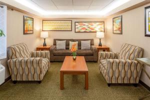 布卢明顿La Quinta Inn by Wyndham Minneapolis Airport Bloomington的客厅配有沙发、两把椅子和一张桌子