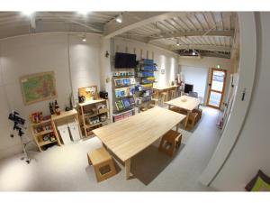 高冈市Travelers' house ROOTs的一间设有一张大木桌和一些架子的房间