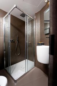 巴黎最佳西方巴黎爱丽舍酒店的浴室设有玻璃淋浴间、卫生间和水槽。