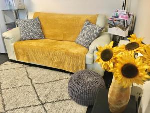 卡纳芬Chapel St Apartments的带沙发和向日葵花瓶的客厅