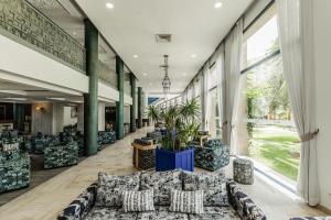 马拉喀什瓦佐酒店的大楼内带有长沙发和植物的走廊