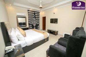 拉合尔Premier Inn Grand Gulberg Lahore的一间卧室配有一张床、一台电视和一张沙发