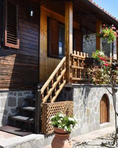 SerravalleBaita La Stradella的木房子,有楼梯和花盆