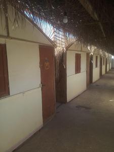 NuweibaElbadawy camp的一座空的建筑,有排门和屋顶