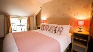 Greenhaugh霍利布什宾馆的一间卧室配有一张床、一张桌子和一个窗户。