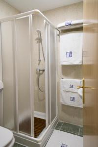 阿卡斯Pradaria Asador & Alojamiento的带淋浴、卫生间和毛巾的浴室