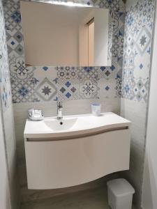 莱乌卡Case Vacanza La Pajara的浴室设有白色水槽和镜子