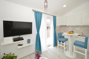 科托尔阿拉霍沃克J＆P公寓的带电视的厨房以及带蓝色椅子的厨房。