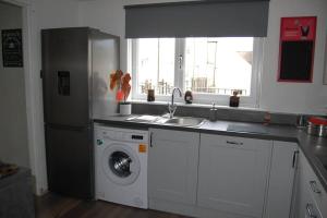 阿伯福伊尔Creag Mhor Self Catering Holiday Apartment的厨房配有冰箱和洗衣机。