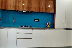 海得拉巴RESTEL STUDIO FLATS的厨房配有白色橱柜和蓝色的墙壁