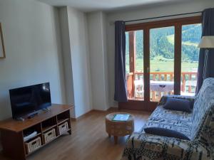 埃尔塔特Terrasses- Vacances Pirinenca的带沙发、电视和窗户的客厅