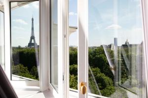 巴黎Le Damantin Hôtel & Spa的享有艾菲尔铁塔景致的开放式窗户