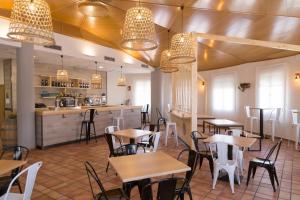 阿卡斯Pradaria Asador & Alojamiento的一间带桌椅的餐厅和一间酒吧