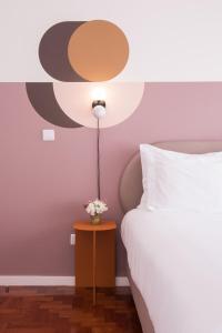 里斯本Lisbon Serviced Apartments - Campos的一间卧室配有一张床和一张鲜花桌