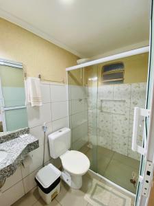 卡塔洛Hotel Pousada Marra的一间带卫生间和玻璃淋浴间的浴室