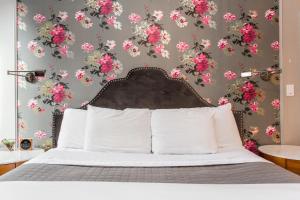 芝加哥柳条公园酒店的卧室配有一张墙壁上粉红色鲜花的床