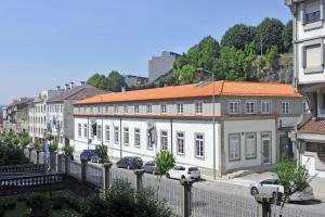 布拉加HI Braga - Pousada de Juventude的白色的建筑,在街上有橙色的屋顶