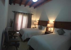 迪坡斯特兰Hotel Concierge Flor y Canto的酒店客房设有两张床和两盏灯。