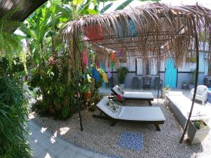 雅科Hotel Perico Azul & Surf Camp的花园设有带沙发和桌子的凉亭