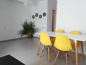 圣克鲁斯-德拉帕尔马Franja de Mar - Duplex amplio y luminoso的一间带桌子和黄色椅子的用餐室