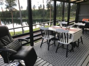 BrännanTallbacken Fritidsby的湖景门廊配有桌椅