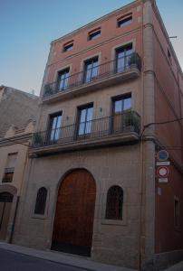 巴拉格尔La Casa Del Miracle的一座高大的砖砌建筑,设有门和阳台