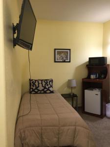 坎特韦尔Cantwell Lodge的一间卧室配有一张床和一台平面电视