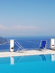 拉维罗Villa Casale Ravello Residence的两把椅子坐在游泳池边