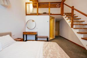 坎普朗莫道尼斯Buchenland Hotel的一间卧室设有一张床和木制楼梯。