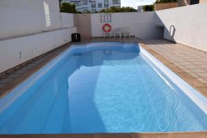圣卢西亚岛Piscina Apartment的大楼一侧的大型蓝色游泳池