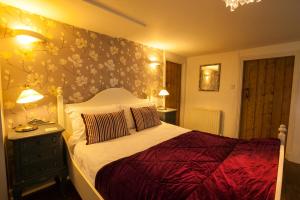 Greenhaugh霍利布什宾馆的一间卧室配有一张带花卉墙壁的床