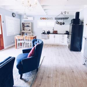 陶朗加Sunny Brae Cottages的一间带两把椅子的客厅和一间厨房