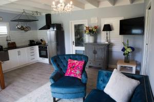 陶朗加Sunny Brae Cottages的客厅配有带粉红色枕头的蓝色椅子
