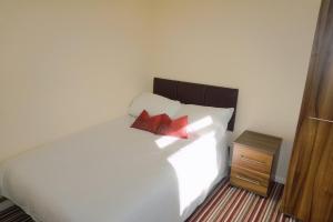 坎特伯雷The Harvest 2的卧室配有白色床和2个红色枕头