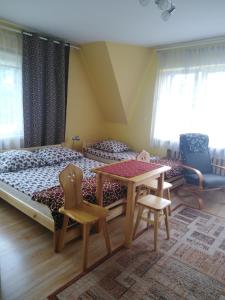 扎沃亚Trybałowa Ostoja的卧室配有一张床和一张桌子及椅子