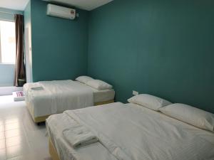 巴西富地Qeyjan Hotel的一间卧室设有两张床和蓝色的墙壁